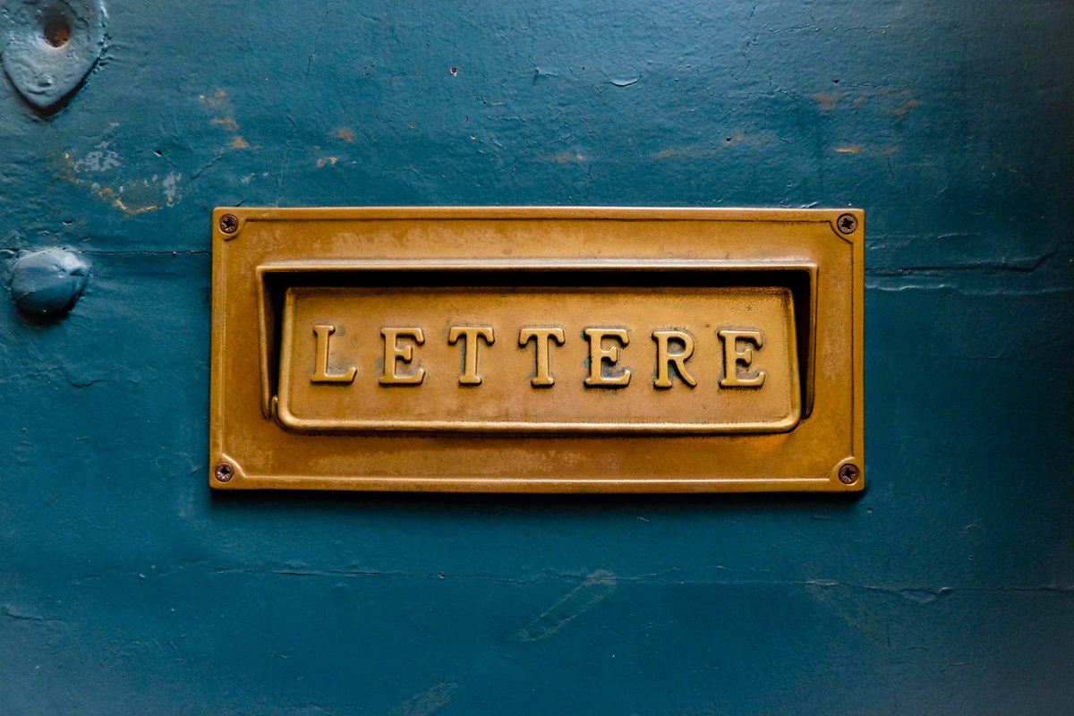 Goldener Briefkastenschlitz in blauer Tür