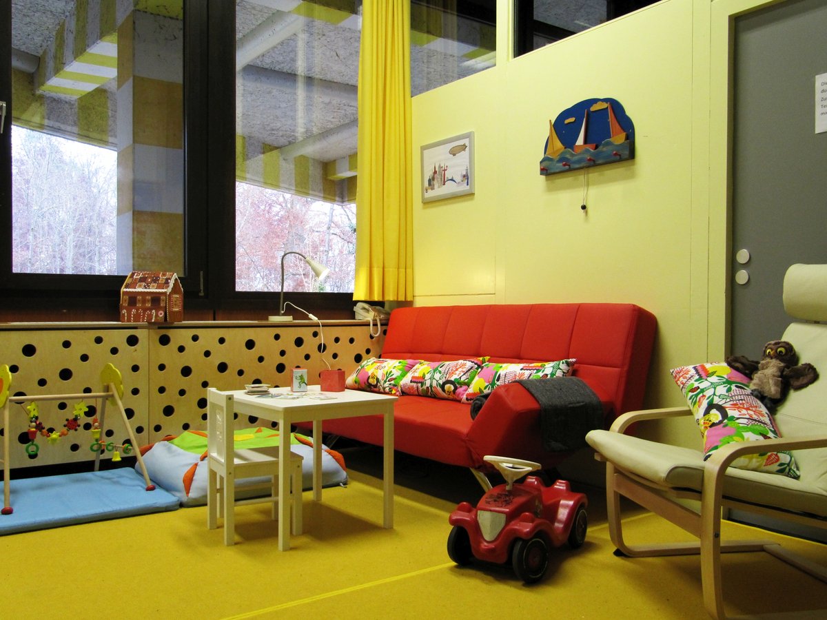 Innenansicht Still- und Wickelzimmer mit Sofa und Spielzeug